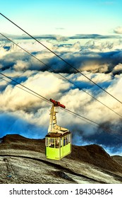 Cable Car Going Up To The Top Of The Mountain Over The Clouds