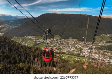 Cable car "Mont Sëuc" riding from Ortisei to Alpe di Siusi (Seiser Alm). View of Ortisei, also called St. Ulrich in Gröden or Urtijëi, in the Val Gardena valley. South Tyrol, Dolomites, Alps, Italy - Powered by Shutterstock