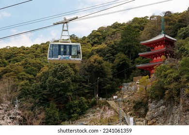 A cable car of Mount Kinka Ropeway gliding before the Sanjo Tower 三重塔 (a traditional Japanese three-story pagoda), which stands in Gifu Park at the foothill of Mt. Kinka 金華山, in Gifu, Japan