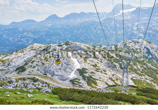 Cable Car to Mountain Dachstein in Salzkammergut\
region. Austrian Alps. Neutral colors. Beautiful Mountains\
landscape with blue sky.
