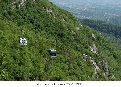 Cable Car Moving Up A Mountain With A View Of The City