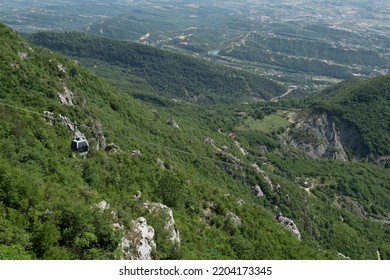 Cable Car Moving Up A Mountain With A View Of The City