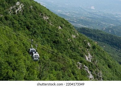 Cable Car Moving Up A Mountain With A View Of The City