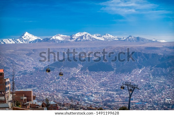 Cable car in a panoramic view of the city of La\
Paz, Bolivia. Behind, you can see The Andes mountain range with\
peaks full of snow. Latin\
America