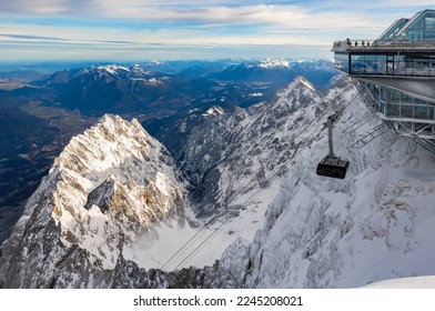Cable car reaching the modern mountain station “Zugspitze“ (2962 m) on highest peak of Germany and part of the “Wetterstein“ alpine range near Garmisch-Partenkirchen in winter. Panoramic view. - Powered by Shutterstock