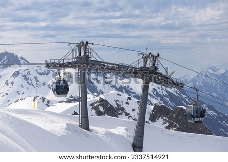 Cable car road of Rosa Khutor against snowy mountain peaks. Funicular cableway to ski resort Rosa Khutor in Krasnaya Polyana at Sochi