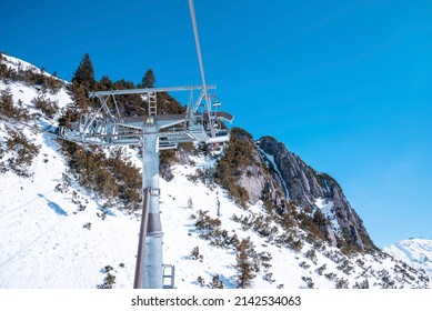 Cable cars pulley on snowy landscape. Aerial tramcar against clear blue sky. Scenic view of white mountains.