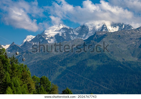 Cable cars sit\
idle on the gondola in Verbier Switzerland just with the  Grand\
Combin glacier in the\
background