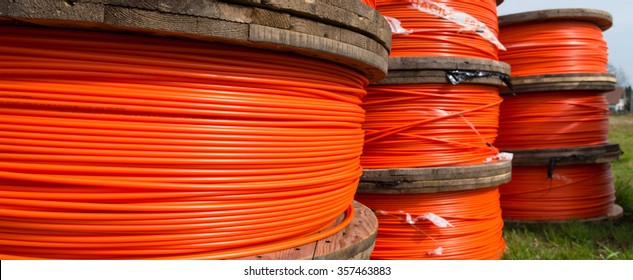 cable drums with orange fiber cable on a construction site