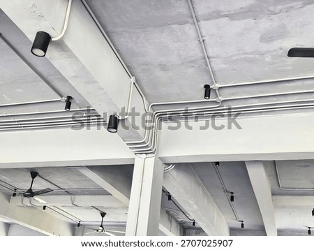 Cable installation with an industrial concept using cables wrapped in conduit which is attached to the ceiling of the room