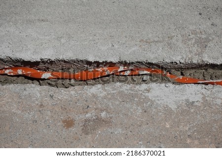 Cable insulation for underground wires passing through trench under street concrete. Undergrounding electric lines.