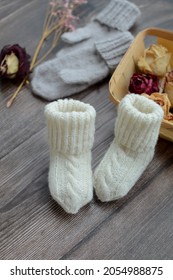 Cable Knit  Baby Socks Made Of Organic Wool Yarn, On Dark Wooden Background