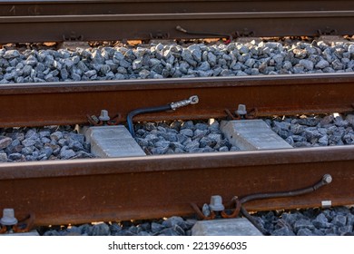 Cable Lugs On A Rail On A Railroad Track In A Ballast Bed