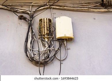 Cable Power Cords In Tangled Mess On Building Wall Outdoor