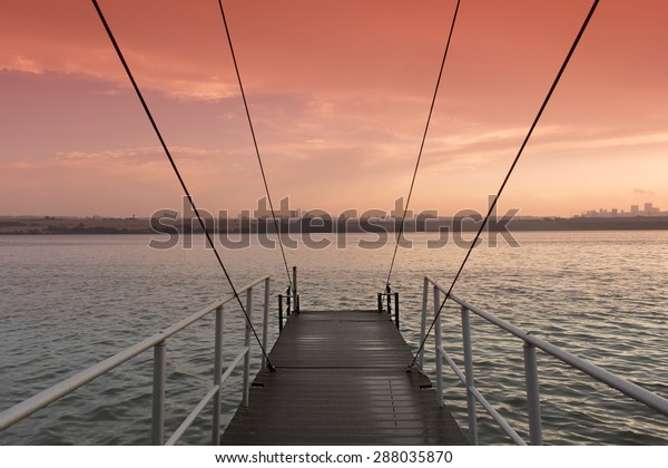cable stayed\
bridge over the lake with sunset\
