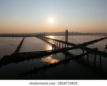 Cable stayed bridge over St Lawrence River at golden sunrise near Montreal and Brossard, Canada. g.