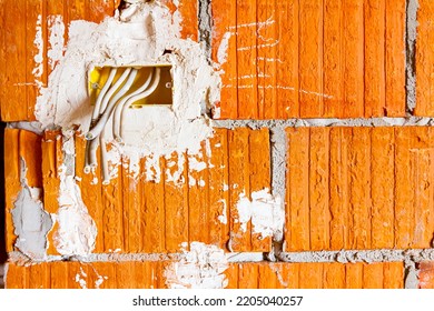 Cables Are Hanging From Junction Box Placed On The Wall Of Building Under Construction, Work In Progress. Placement Of Electrical Wires And Cables.