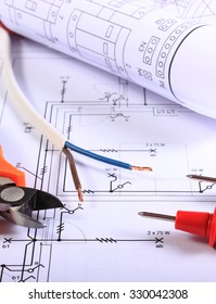 Cables of multimeter, metal pliers, electric wire and construction drawings, electrical drawings and tools for engineer jobs
