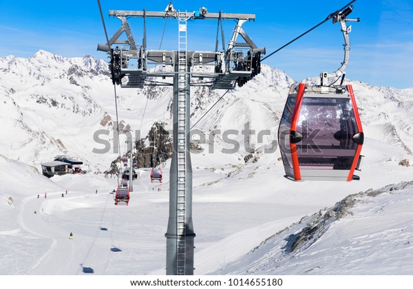 Cableway lift cable cars,\
gondola cabins on winter snowy mountains background beautiful\
scenery.