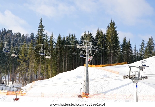 Cableway lift gondola cabins on winter snowy\
mountains background beautiful\
scenery