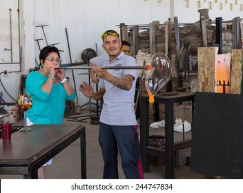 Cabo San Lucas, MEXICO - April 8 2014- An Unidentified Glass Blower Shows An Unidentified Woman How To Blow Glass At Glass Blown Factory On  April 8 2014  In Cabo San Lucas, Mexico.