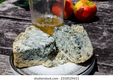 Cabrales blue cow's milk cheese and apple cider is glass made by rural farmers in Asturias, Spain, Las Arenas in Picos de Europa mountains, on old wooden table - Shutterstock ID 2318529611