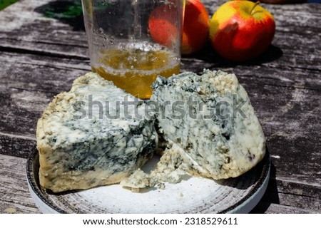 Cabrales blue cow's milk cheese and apple cider is glass made by rural farmers in Asturias, Spain, Las Arenas in Picos de Europa mountains, on old wooden table