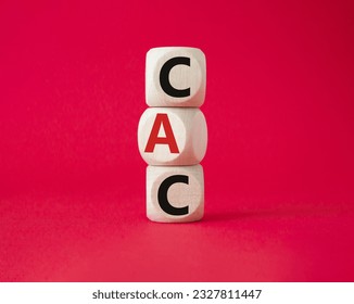 CAC - Customer Acquisition Cost symbol. Wooden cubes with word CAC. Beautiful red background. Business and Customer Acquisition Cost concept. Copy space.