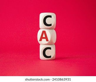 CAC - Customer Acquisition Cost symbol. Wooden cubes with word CAC. Beautiful red background. Business and Customer Acquisition Cost concept. Copy space.