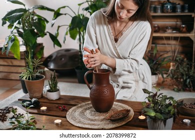 Cacao Ceremony In Atmospheric Space With Green Plants And Candles. Woman Making Ritual Healthy Drink From Cocoa Beans Person Whipping Hot Fresh Chocolate Drink