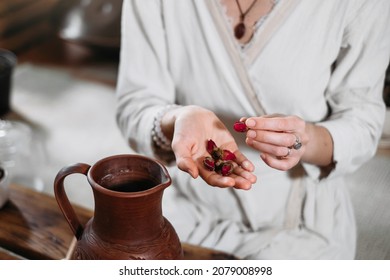 Cacao Ceremony In Atmospheric Space With Green Plants And Candles. Woman Making Ritual Healthy Drink From Cocoa Beans. Person Putting Rose Flower To Hot Fresh Chocolate Drink