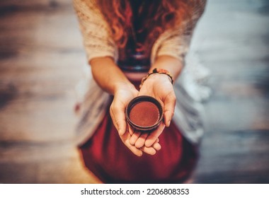 Cacao ceremony, heart opening medicine. Ceremony space. Cacao cup in woman's hand.