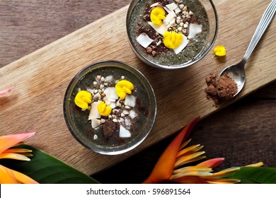 Cacao Spinach  Smoothie Topped With Buckwheat, Coconut Flakes And Edible Flowers.