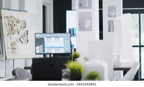 Cad architecture software on computer at empty office desk, urbanistic project plans and blueprints placed on table. Modern engineering unicorn business workstations with industrial tools.