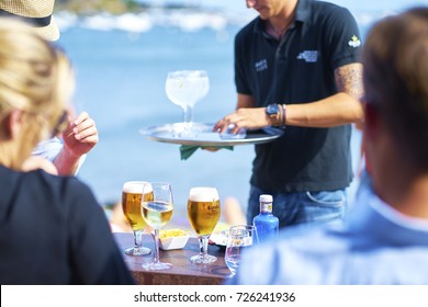 Cadaques, Spain-Aug. 19, 2017: bartender serving drinks to travelers on beach of Cadaques, Spain on Aug. 29, 2017