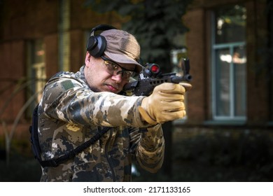 Cadet Training Course, Man With Gun In Military Uniform Tactical Hearing Protector Headset. Training In Shooting Operations Center. Civil Police Man In Tactical Training Course. Selective Focus.