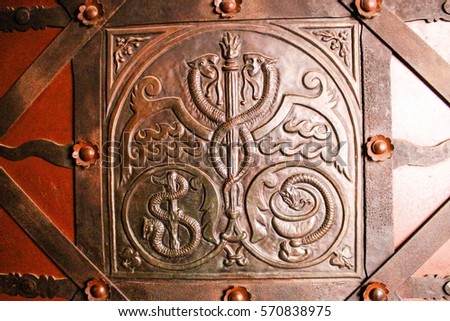 Caduceus, Rod of Asclepius and Bowl of Hygieia incused on the door of Medieval pharmacy