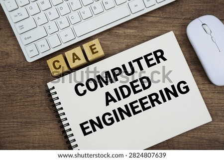 CAE Computer Aided Engineering message with keyboard and optical mouse on wooden background