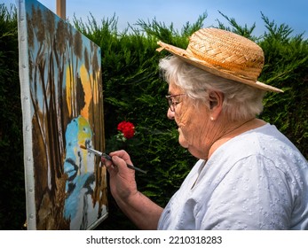 Caen, France August 2022. Artist Painter Elderly Woman Paints Landscapes. Hobbies, Free Time, Relaxation. Grandma Painting Pictures