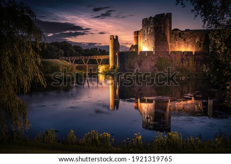 Caerphilly castle south wales with Noctilucent clouds and reflected in the moat