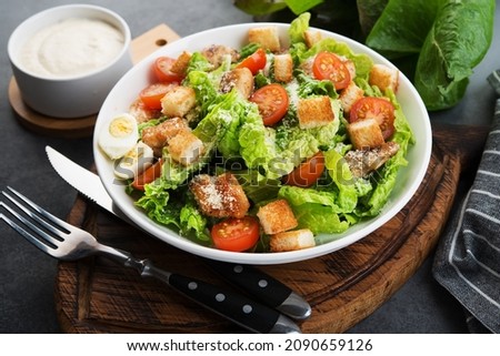 Caesar salad with chicken fillet, cherry tomatoes and croutons, traditional Italian food, close up