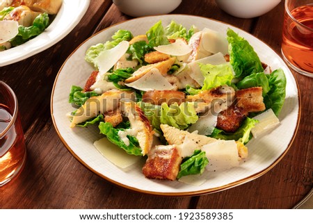 Caesar salad close-up. Grilled chicken breast slices, green romaine salad leaves, croutons and Parmesan, the classic recipe