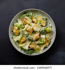 Caesar Salad With Croutons And Parmesan Cheese On Dark Background