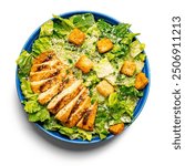 Caesar salad, a delicious salad with chicken, crackers and herbs on a beautiful plate isolated on white background 