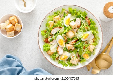 Caesar salad with grilled chicken breast, hard-boiled egg, croutons, parmesan cheese, green salad lettuce and dressing