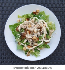 Caesar salad with grilled chicken lettuce mayonnaise croutons and grated cheese.