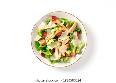 Caesar salad with grilled chicken meat, romaine and Parmesan, shot from the top on a white background