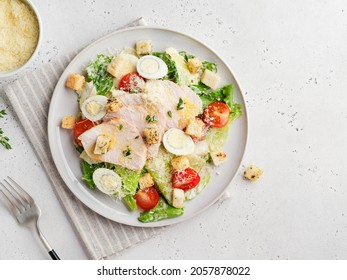 Caesar salad. Healthy salad made of baked turkey breast, romaine lettuce, cherry tomatoes, quail eggs, croutons, parmesan and thyme olive oil. Step by step cooking. Grey concrete background. Top view. - Powered by Shutterstock