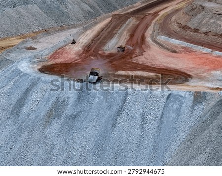CAEX mining trucks dumping material at the end of an open-pit road