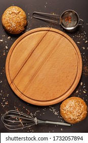 Cafe Or Bistro Menu Cover As Black Textured  Backgroond With Wooden Round Kitchen Board, Peppercorns, Sesame, Sunflower Beans, Spice, Two Cruft Buns, Kitchen Whisk And Strainer Design Composition